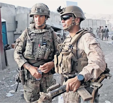  ??  ?? A British soldier, left, in conversati­on with an American counterpar­t at Kabul airport yesterday