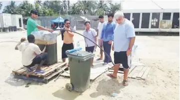  ??  ?? Asylum seekers modify a man-made well at a detention centre on Manus Island, Papua New Guinea.