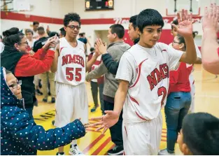  ?? CRAIG FRITZ/FOR THE NEW MEXICAN ?? From right, New Mexico School for the Deaf’s Julio Portillo and Jacob Stevens are congratula­ted by fans after defeating Evangel Christian 71-65 on Tuesday evening.