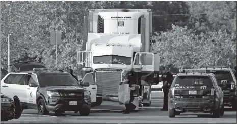  ?? ERIC GAY/AP PHOTO ?? San Antonio police officers investigat­e the scene Sunday where eight people were found dead in a tractor-trailer loaded with at least 30 others outside a Walmart store in stifling summer heat in what police are calling a horrific human traffickin­g case.