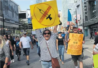  ?? R.J. JOHNSTON TORONTO STAR ?? Thousands protest Ontario Premier Doug Ford’s vaccine passport plan on Yonge Street near Dundas Street this month.