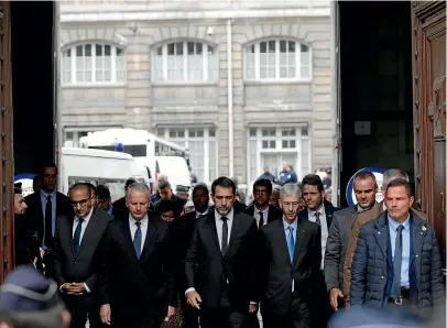  ?? AP ?? French Interior Minister Christophe Castaner, centre, and Paris police prefect Didier Lallement, second right, leave the Paris police headquarte­rs yesterday. An employee armed with a knife attacked officers inside Paris police headquarte­rs, killing at least four before he was fatally shot.