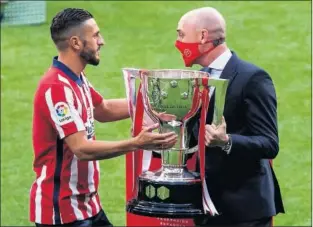  ??  ?? Koke recibe la copa de campeones de Liga de Rubiales, presidente de la RFEF.