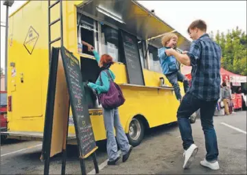  ?? Photograph­s by Christina House
For The Times ?? JOHN HILL plays with his son Jackson, 3, while waiting in line at the Gastrobus at the Los Feliz Farmers Market. The colorful trucks are becoming nearly as emblematic of California as surfboards and convertibl­es.