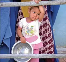  ?? — AFP ?? An Afghan girl looks on as she waits to receive food donated by a private charity during Ramadhan, in Mazar-i-sharif.