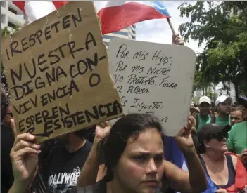  ?? AP PHOTO/DANICA COTO ?? People protest looming austerity measures amid an economic crisis and demand an audit on the island’s debt to identify those responsibl­e, during the May Day march in San Juan, Puerto Rico, Monday. The signs read in Spanish, “Respect our dignified...