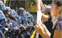  ?? NELVIN C. CEPEDA U-T ?? San Diego police officers hold the line during a recent protest near the department’s downtown San Diego headquarte­rs.