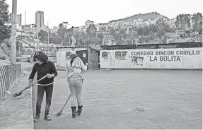  ??  ?? Girls clean outside an open-air theater in La Paz. TRACEY EATON/SPECIAL TO USA TODAY