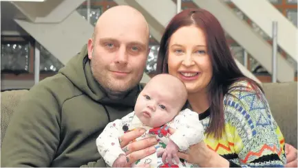  ??  ?? > Little Vinney Holliday at home with parents Ben and Claire after his major heart operation a day after his birth