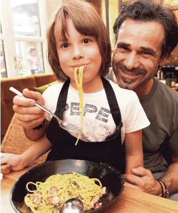  ??  ?? Dem Juniorchef schmeckts. Der siebenjähr­ige Levi kostet die Spaghetti Carbonara im „Pastissima“, dem Restaurant seines Vaters Massimo Siniscalch­i, der aus Kampanien stammt.