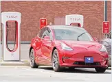  ?? (AP) ?? This file photo, shows a Tesla vehicle charging at a Tesla Supercharg­er site in Charlotte, NC. Tesla’s electric car sales accelerate­d again during the summer, but the company is still lagging behind the pace it needs to reach CEO Elon Musk’s goal for the entire year.