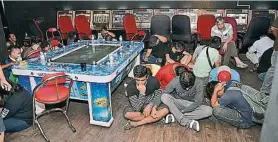  ??  ?? ▲被捕的42名男女賭客，聚集一處等候警方發落。
