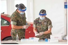  ?? LOUIS TUCKER/THE COMMERCIAL APPEAL ?? National Guard, volunteers and medical staff assist people to vaccinatio­n areas near the Pipkin Building on Wednesday.