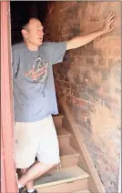  ?? Doug Walker / RN-T ?? Nathan Roberts shows a section of wall between his building at 409 Broad St. where he believes moisture has been coming in.