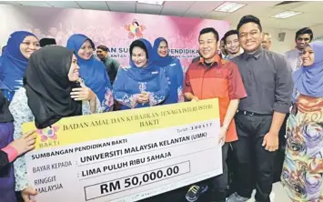  ??  ?? Rosmah (centre) talking with the students of Universiti Malaysia Kelantan (UMK) and Universiti Sains Islam Malaysia (USIM) after presenting education aid of RM100,000. — Bernama photo