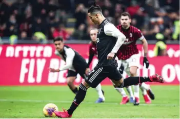  ?? — AFP ?? Juventus’ Cristiano Ronaldo shoots to score a penalty and equalise during the Italian Cup (Coppa Italia) semifinal first leg against AC Milan at the San Siro stadium in Milan.