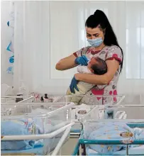  ?? EFREM LUKATSKY THE ASSOCIATED PRESS FILE PHOTO ?? A nurse takes care of babies born to surrogate mothers for foreign parents in a hotel in Kyiv, Ukraine, on May 14.