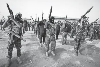  ?? PHOTOS BY HAIDAR HAMDANI, AFP/GETTY IMAGES ?? Members of the Saraya al-Salam, a group formed by Muqtada al-Sadr, march in Najaf, Iraq, on Tuesday as they prepare to reinforce government forces against ISIL for control of Fallujah.