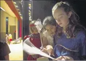  ?? BRANDON DILL/SPECIAL TO THE COMMERCIAL APPEAL ?? Eden Waite, 10, (from left) Anna Fung, 10, and Autumn Chance, 11, look over the script for “Pinocchio” backstage while performing the play at the Bartlett Performing Arts and Conference Center, the culminatio­n of one of BPACC’s annual Summer Theatre...