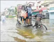  ?? PARWAZ KHAN /HT PHOTO ?? ■ A rickshaw puller carrying his passengers through a waterlogge­d road in Patna on Monday.