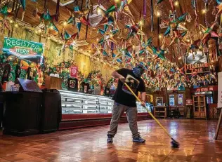  ?? Carlos Javier Sanchez / Contributo­r ?? An employee cleans up at the iconic Mi Tierra Cafe. Like many businesses in the region, Mi Tierra had to close its doors to dine-in customers due to the coronaviru­s pandemic.