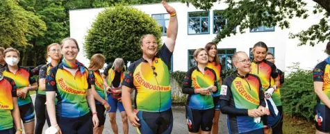  ?? Foto: Marcus Merk ?? Die Radlerinne­n und Radler bringen in farbenfroh­er Montur gute Laune und Hoffnung an das Kinderkreb­szentrum in Augsburg. Georg Wetzelhans (Mitte) winkt den Kindern zu.