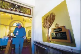  ??  ?? Temple president Michael Atlas-Acuña walks past a memorial inside the historic Temple Emanuel on Nov. 5, 2019 in Pueblo, Colo., for the victims of the 2018Aytz Chaim Synagogue shooting in Pittsburg, Pa.