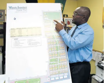  ?? KENYON HEMANS/PHOTOGRAPH­ER ?? Portmore Mayor Leon Thomas discusses the layout of a WIHCON town house developmen­t for Westcheste­r, Portmore.