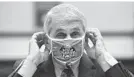  ?? KEVIN DIETSCH/AP ?? Dr. Anthony Fauci adjusts his face mask.