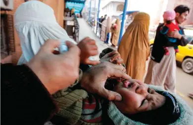  ?? — AP/PTI ?? A health worker gives a polio vaccine to a child in Peshawar, Pakistan, Monday. Polio remains endemic in Pakistan after the Taliban banned vaccinatio­ns, instigated attacks targeting medical staffers and spread suspicions about the vaccine.