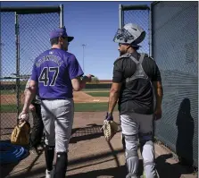  ?? AARON ONTIVEROZ — THE DENVER POST ?? Rockies pitcher Cal Quantrill and catcher Elias Diaz talk as they walk to the bullpen during spring training on Feb. 22 at Salt River Fields in Scottsdale, Ariz.