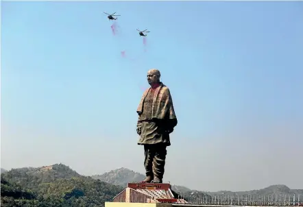  ?? AP ?? Helicopter­s shower flowers petals on the Statue of Unity during its inaugurati­on at Kevadiya Colony in Narmada district of Gujarat State, India.