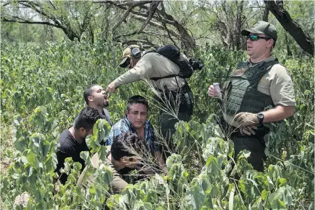  ?? PHOTOS: CAROLYN VAN HOUTEN/WASHINGTON POST ?? A Border Patrol agent gives a drink to a man detained with others at the border in Mission, Texas.