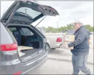  ?? LYNN KUTTER ENTERPRISE-LEADER ?? Jeff Bonacci of Fayettevil­le, a former athletic director for Lincoln Consolidat­ed School District, loads two boxes of Tyson breaded chicken tenders into a waiting vehicle. Bonacci was one of many volunteers.
