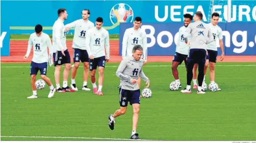  ?? VÍCTOR LERENA / EFE ?? El selecciona­dor español, Luis Enrique Martínez, con parte de su plantilla al fondo en un entrenamie­nto en Las Rozas.