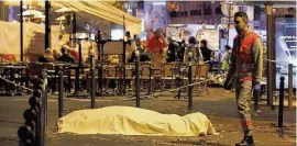  ??  ?? A victim’s body lies covered close to the Bataclan theatre, on November 14, 2015