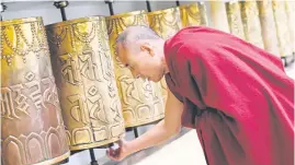  ?? Picture: AFP ?? HOLDING ON TO THE OLD WAYS. A Buddhist monk spins a prayer wheel at Namgyal Monastery in McLeod Ganj near Dharamsala.