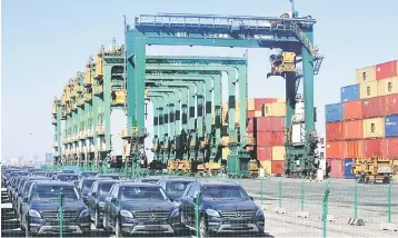  ??  ?? Imported Mercedes Benz cars are seen next to containers at Tianjin Port, in northern China. Passenger car sales fell to 22.4 million vehicles in 2018, down 5.8 per cent from a year earlier, data from the China Passenger Car Associatio­n (CPCA) showed on Wednesday. — Reuters photo