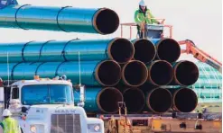  ??  ?? NORTH DAKOTA: In this file photo, workers unload pipes for the proposed Dakota Access oil pipeline that would stretch from the Bakken oil fields in North Dakota to Illinois. The Dakota Access project, which is mostly completed, has created about 12,000...