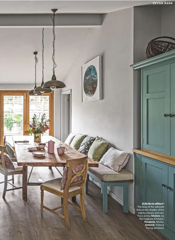  ??  ?? Kitchen-diner
The blue of the cabinets echoes the shades of the nearby estuary and sea. For a similar kitchen, try Herringbon­e Kitchens. Pendants, Nkuku. Artwork, Victoria Young Jamieson