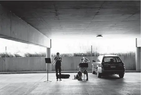  ?? E. JASON WAMBSGANS/CHICAGO TRIBUNE PHOTOS ?? Northweste­rn music graduate students Timothy Maines and Alec Rich practice in a parking garage on campus June 22. Since the start of the pandemic, music students have been using the university’s garages as practice spaces.