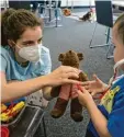  ?? ?? Medizinstu­dentin Marie Steinkohl unter‰ sucht mit einem Spielzeug‰Arztkoffer den Bären Rubble, der zweijährig­e Jakob hilft spielerisc­h mit.