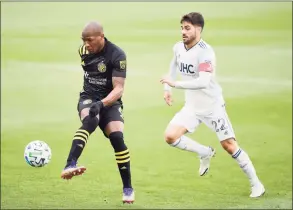  ?? Emilee Chinn / Getty Images ?? The Crew’s Darlington Nagbe controls the ball against the Revolution’s Carles Gil in the first half during the Eastern Conference Final of the MLS Cup Playoffs at MAPFRE Stadium on Sunday in Columbus, Ohio. Columbus won 1-0.