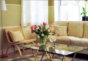  ??  ?? Wide horizontal stripes add a character boost to the walls of this living room. For a bit of sparkle, designer Debbie Travis also created a design of wavy metallic stripes on this glass tabletop.