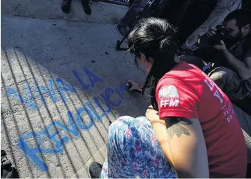  ?? PHOTO: REUTERS ?? Showing support . . . A demonstrat­or sprays a graffiti that reads ‘‘long live the revolution’’ outside the US embassy in Buenos Aires during a rally in support of Venezuelan President Nicolas Maduro earlier this month.