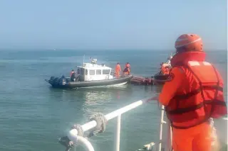  ?? TCG HANDOUT PHOTO VIA AP ?? CLAIM TO BLAME
Taiwanese Coast Guard (TCG) personnel inspect a vessel that capsized during a chase off the Kinmen islands in Taiwan on Feb. 14, 2024.