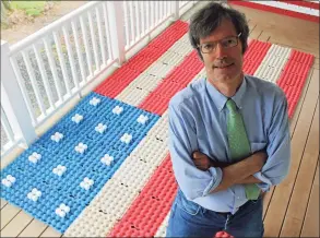  ?? John Breunig / Hearst Connecticu­t Media ?? Robert Carley on the porch of his Darien home, where he creates flag art out of everyday objects, including egg cartons and eggs (background).