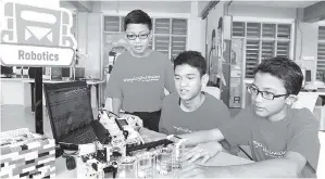  ??  ?? MUHAMMAD Luqman, Muhammad Amirul dan Muhammad Firzan mempamerka­n robot yang mampu mengasingk­an warna ciptaan kumpulan mereka di Nilai. — Gambar Bernama