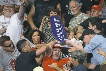  ?? Rebecca Droke/Post-Gazette ?? A protester is pulled out of the crowd as President Donald Trump speaks during a “Make America Great Again” rally Tuesday at the Covelli Centre in Youngstown, Ohio.