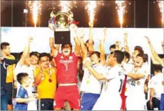  ?? SRENG MENG SRUN ?? Boeung Ket goalkeeper Sou Yaty lifts the Metfone C-League trophy as his teammates celebrate on Saturday.